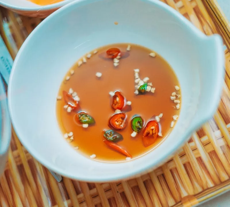 Photo of fish sauce with chilli on a wooden tray by FOX (https://www.pexels.com/@fox-58267/)