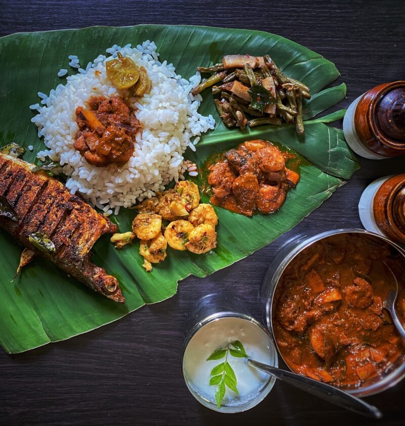 Photo of variety of cooked food on banana leaf